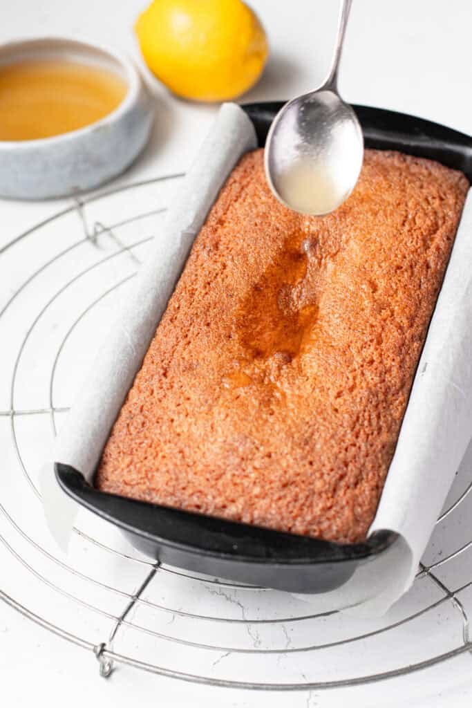 Drizzling lemon syrup on lemon loaf cake