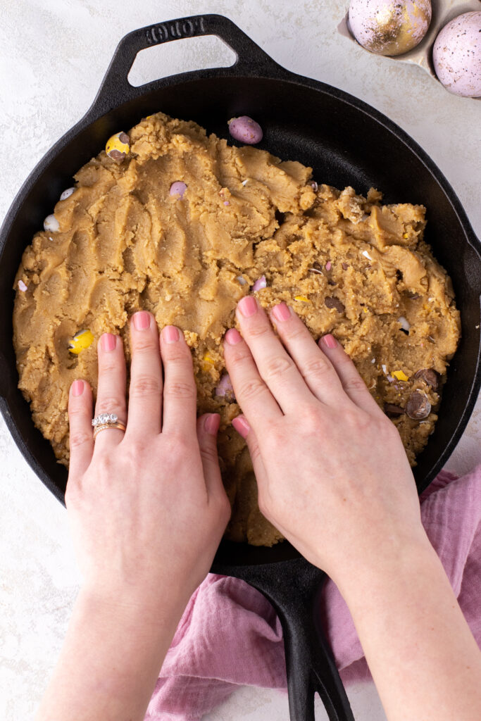 Pressing cookie dough into a skillet pan