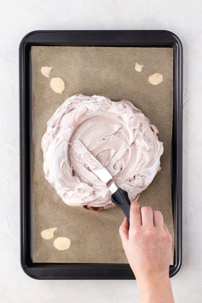 Spreading chocolate pavlova on a baking tray