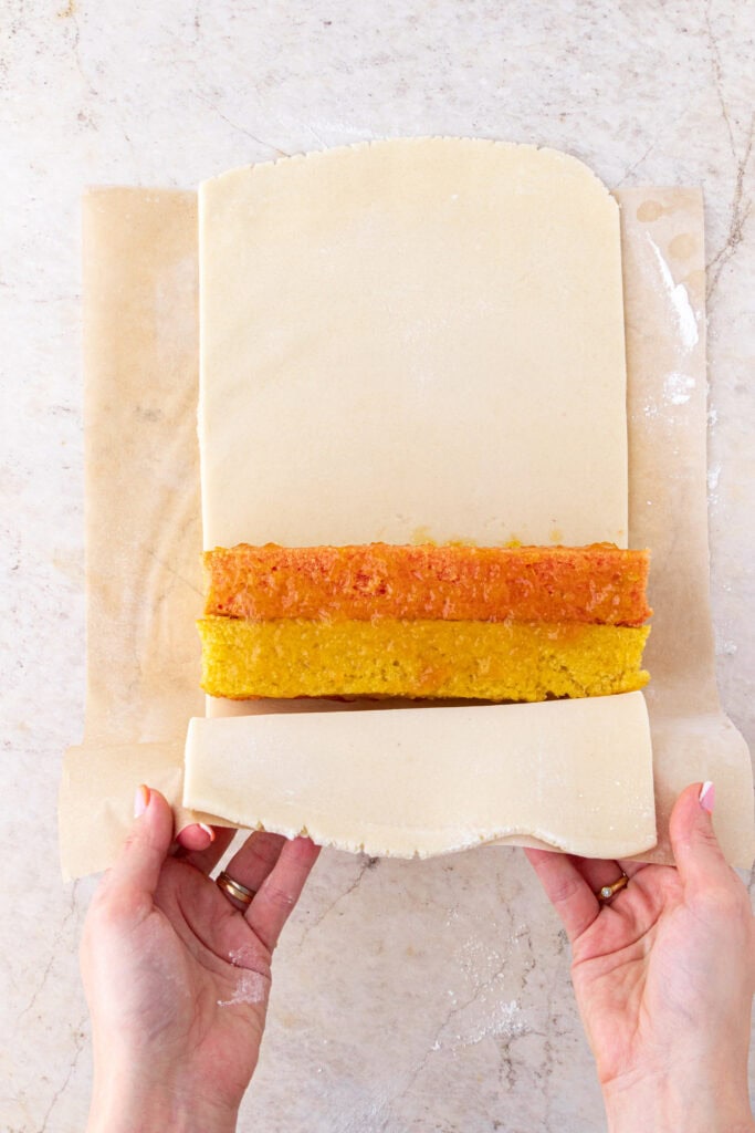 wrapping battenberg cake in marzipan