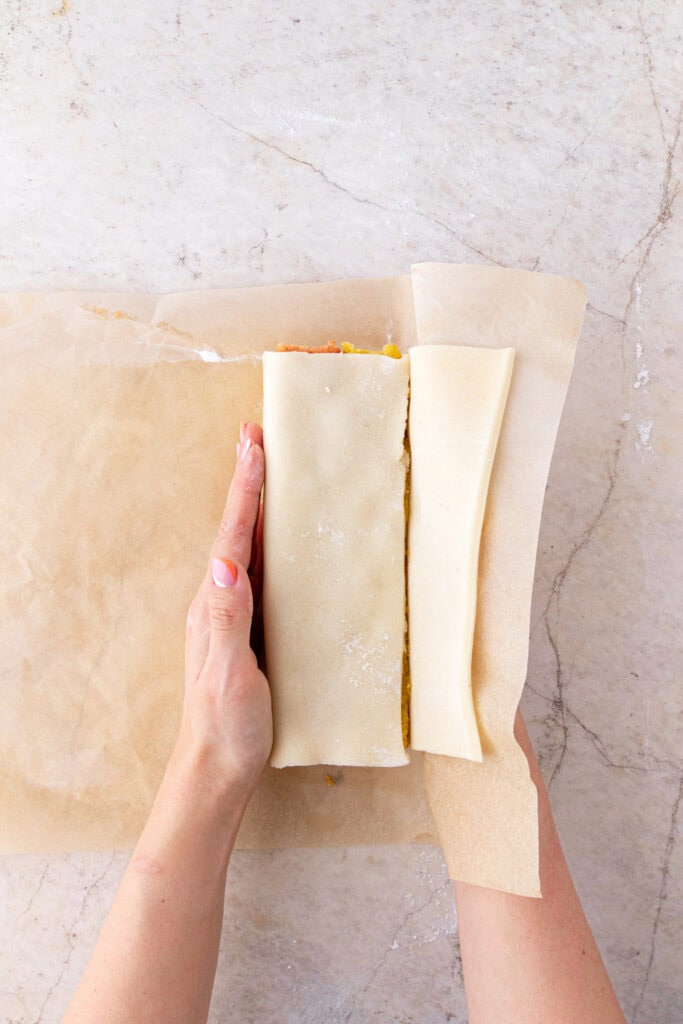 wrapping battenberg cake in marzipan