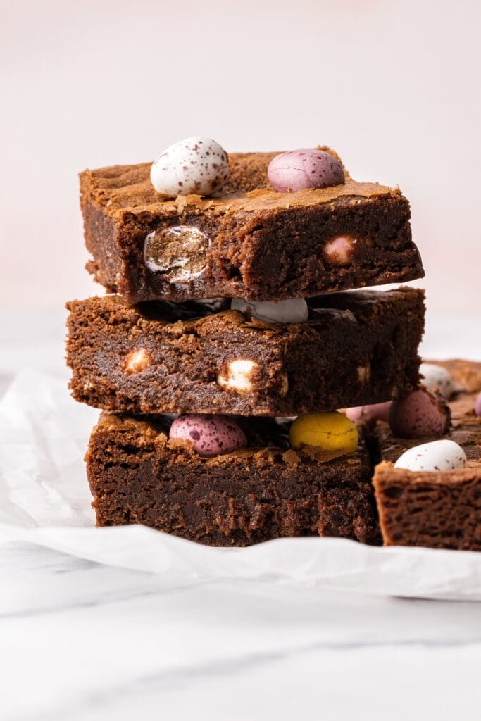 A stack of mini egg brownies with a bite taken out of one