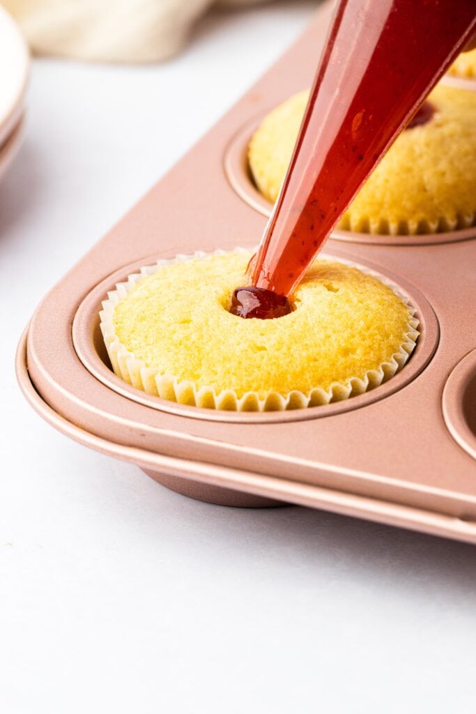 Filling vanilla cupcakes with jam