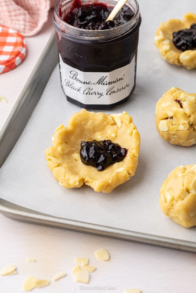 filling the bakewell cookies with cherry jam