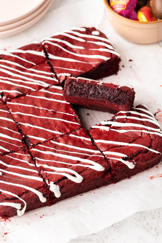 Slice of a dense and fudgy red velvet brownie with cream cheese icing