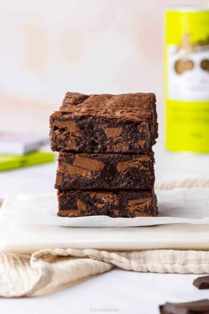 a stack of fudgy brownies with Menier ingredients in the background