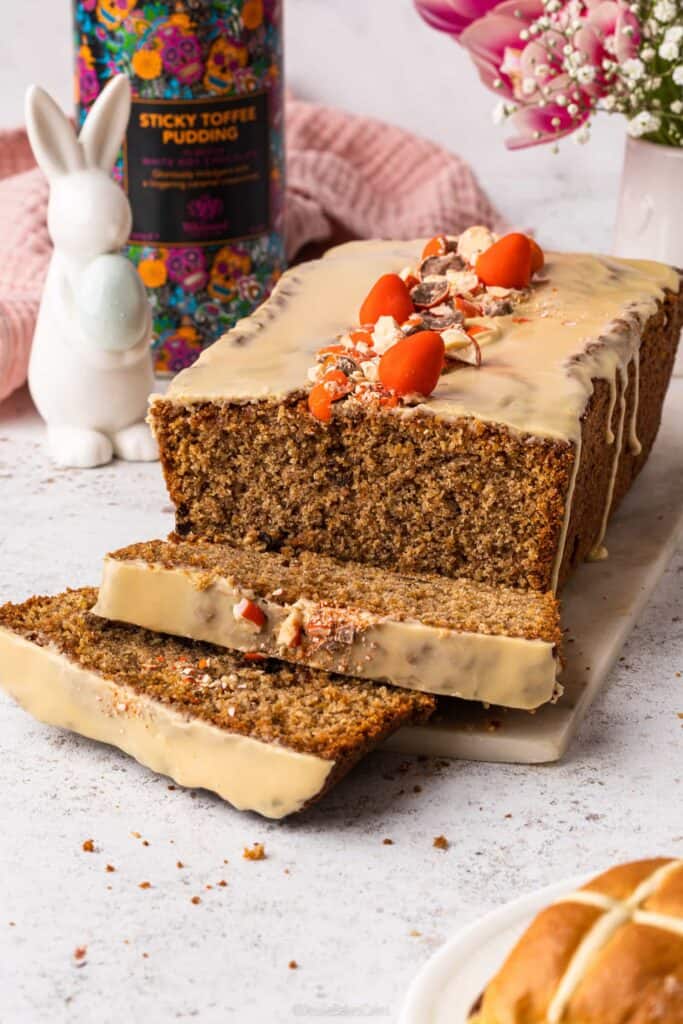 A sticky toffee hot cross loaf cake with two slices cut from it