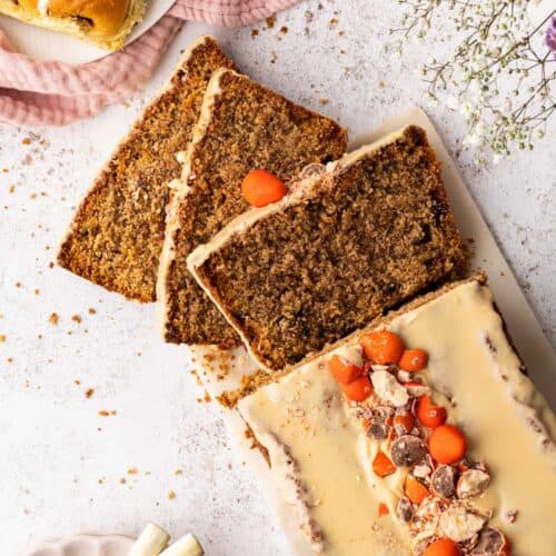 A top down view of A sticky toffee hot cross loaf cake with a slice cut from it