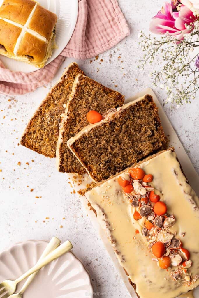 A top down view of A sticky toffee hot cross loaf cake with a slice cut from it