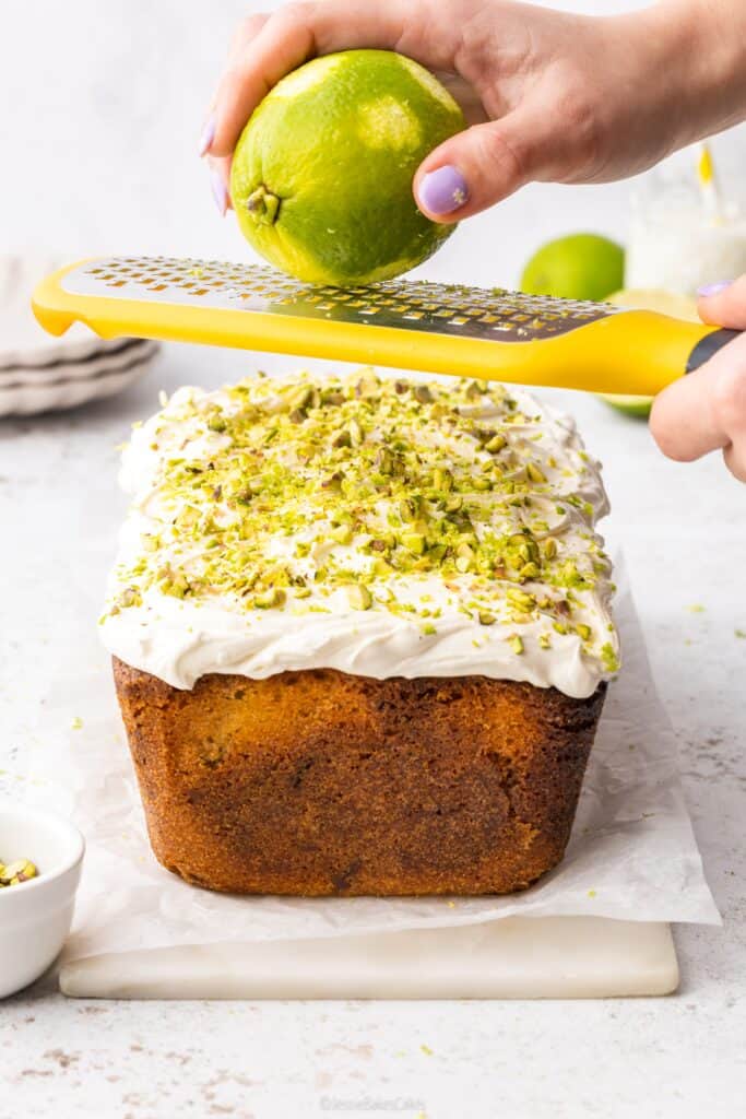 zesting a lime over the cake