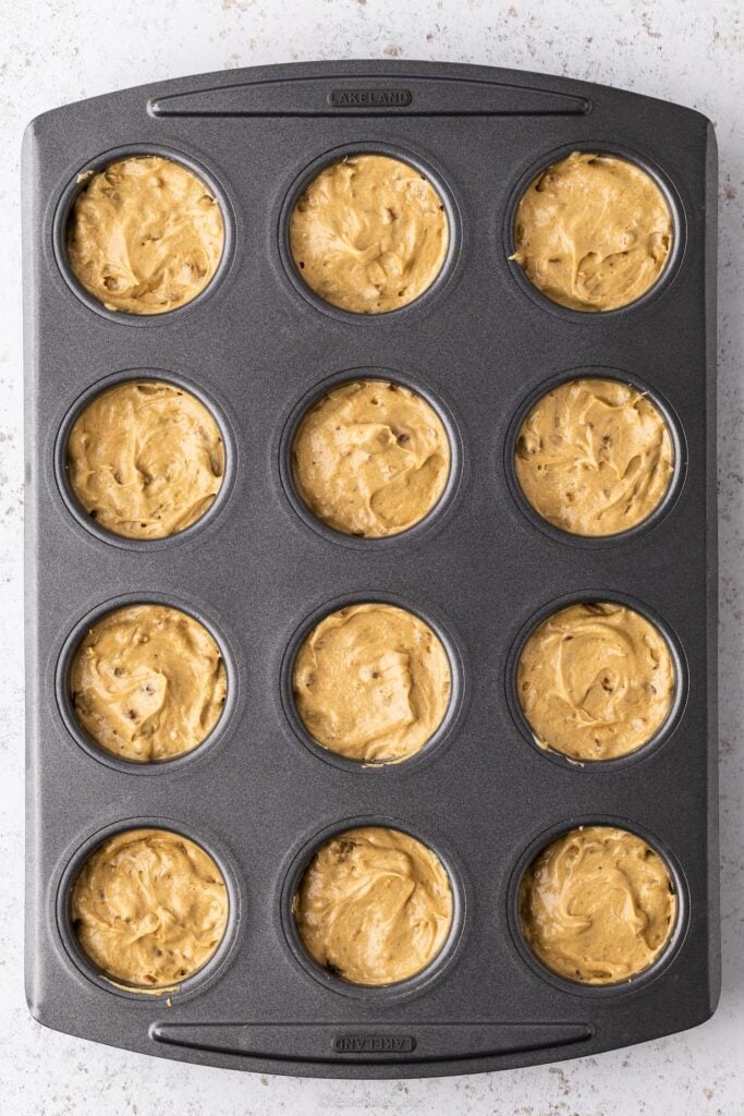 A top down view of a 12 hole muffin tin with Mini Coffee and Walnut Cake mix