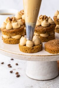 Piping the filling into Mini Coffee and Walnut Cakes