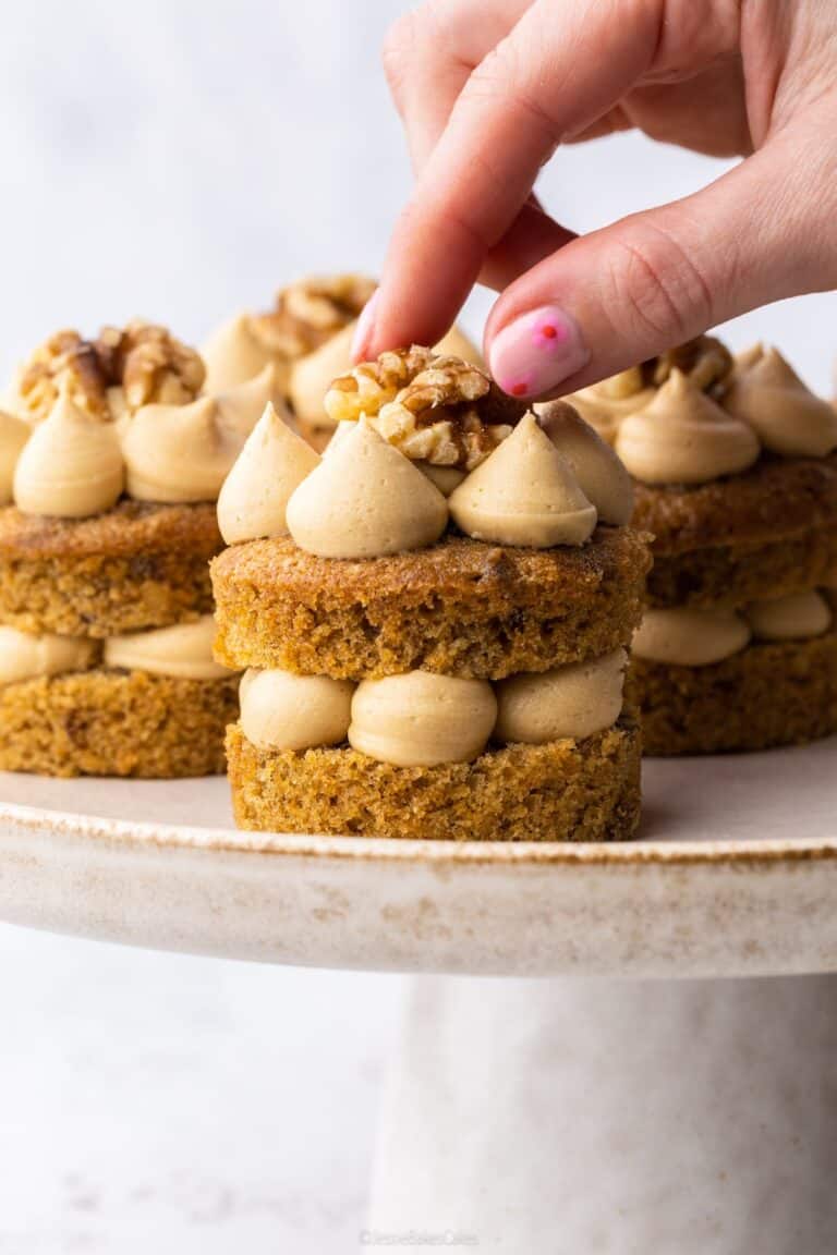 Adding the finishing touches of a walnut to Mini Coffee and Walnut Cakes