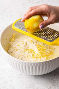 Zesting a lemon into the cake mixture