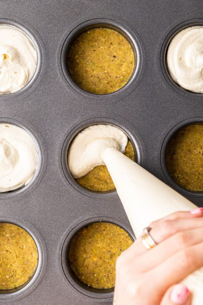 Piping cheesecake mixture onto pistachio biscuit bases