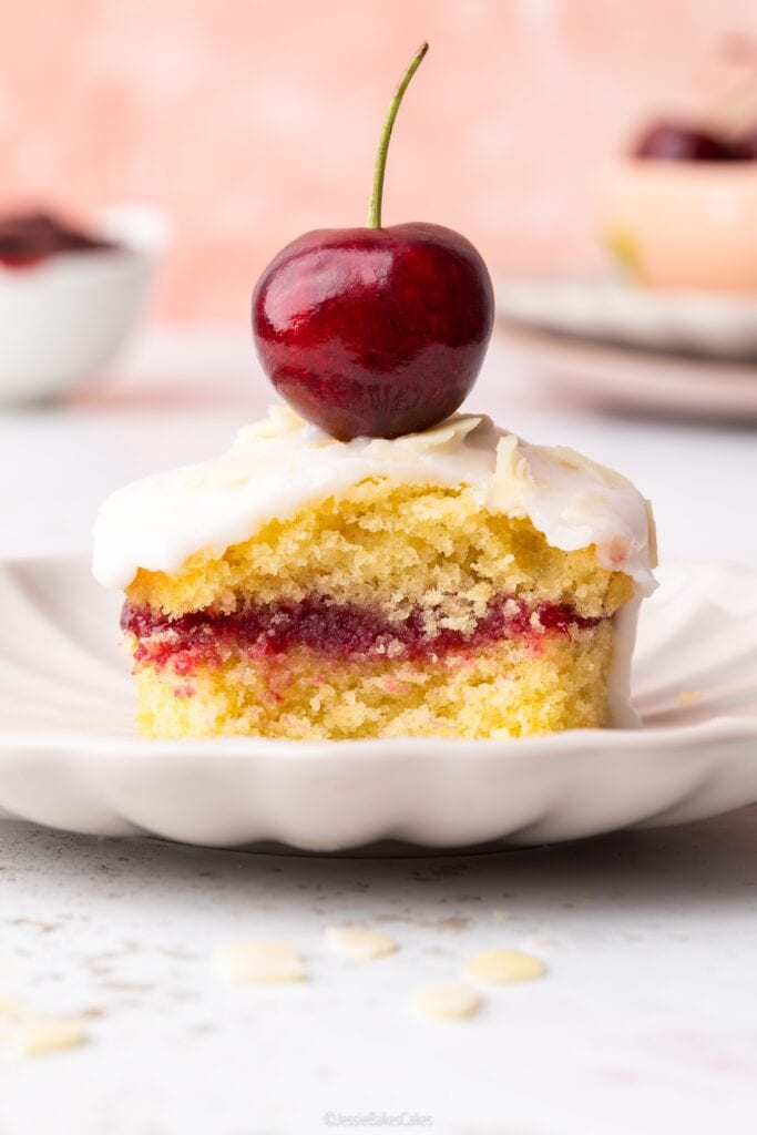 mini cherry bakewell cake on a plate with a cherry on top