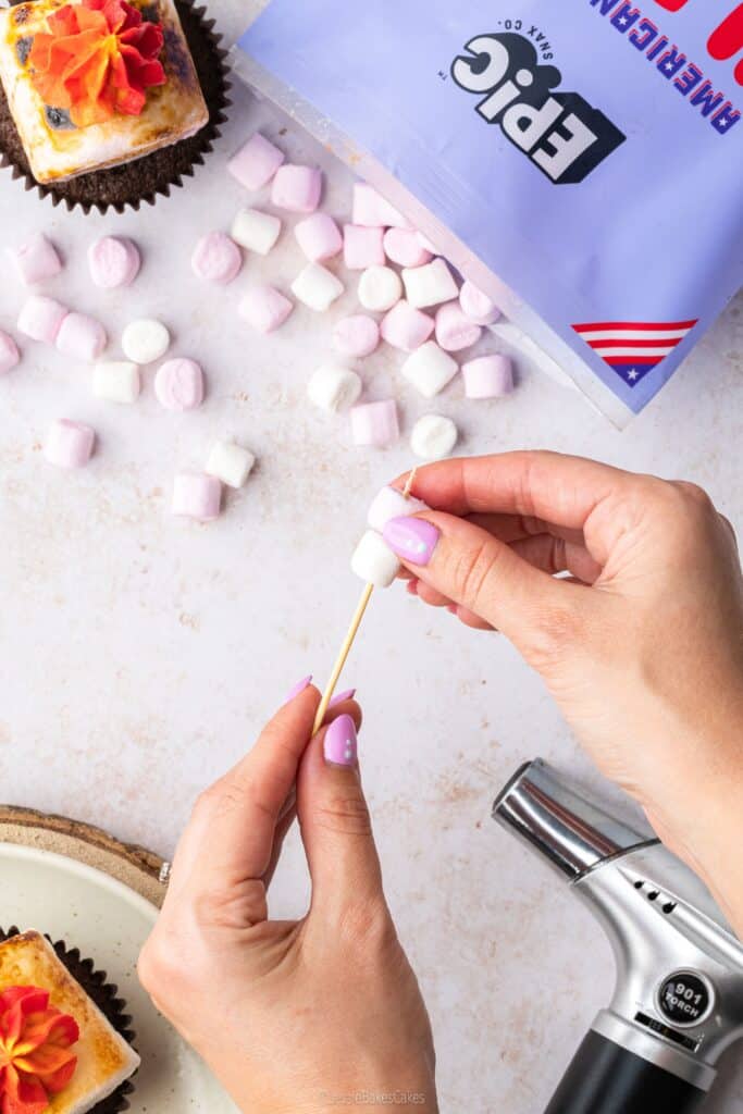 pushing mini marshmallows onto a cocktail stick skewer