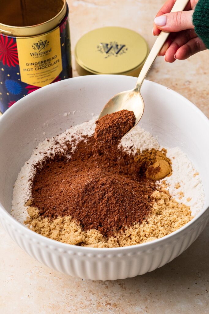 adding whittard gingerbread hot chocolate into a bowl with other dry ingredients to make a cake