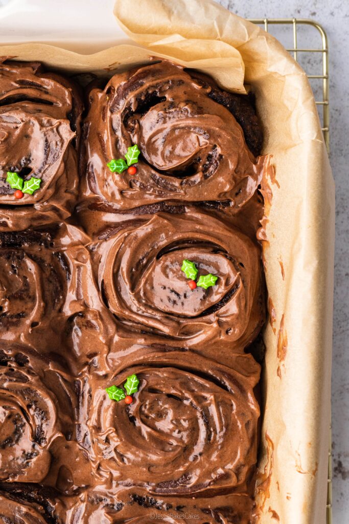a batch of Chocolate Orange Cinnamon Rolls covered in milk chocolate orange cream cheese frosting
