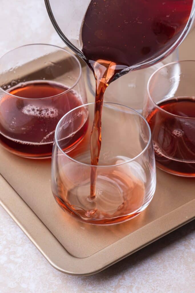 pouring liquid into glasses to make mulled wine jelly