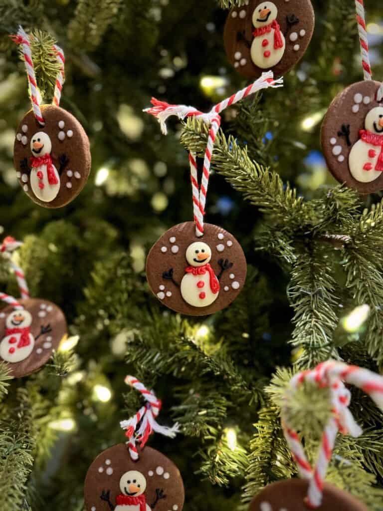 Snowman Bauble Biscuits hanging on a Christmas tree