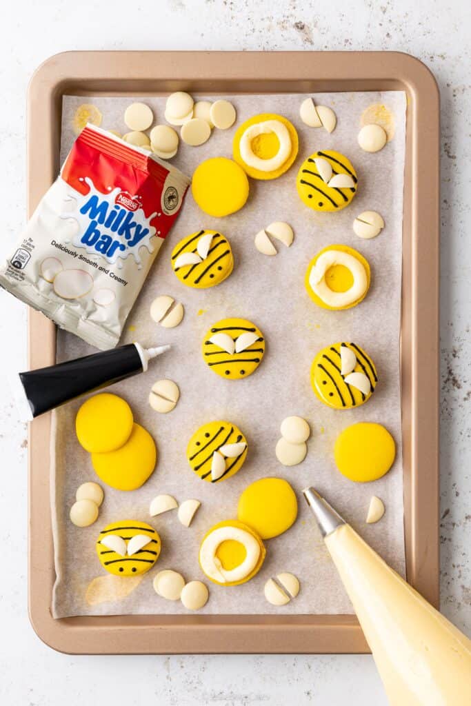decorating bee macarons with milkybar buttons and honey buttercream